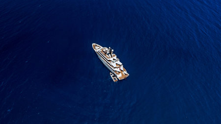 Aerial top view made by drone of big yacht in the blue sea.