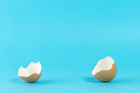 Empty eggshell with on pastel blue background. Minimal Easter holiday concept.
