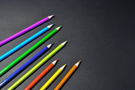 Collection of colored pencils on black background.