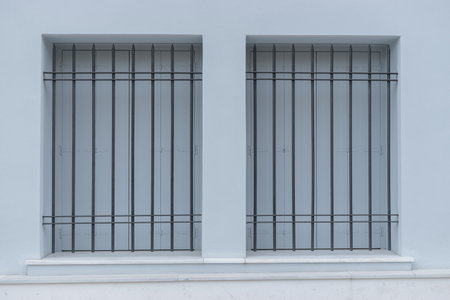 Window with bars on a white wall.の写真素材