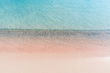 Soft waves of the sea on the pink sand and beautiful beach with cliffs.Coast of Crete island in Greece. Pink sand beach of famous Elafonisiの写真素材
