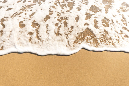 Wave of the sea with foam on the sand beach.