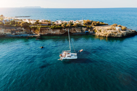 Drone view of Catamaran anchored in blue sea with swimming people. Travel background. Cruise vacation.の写真素材
