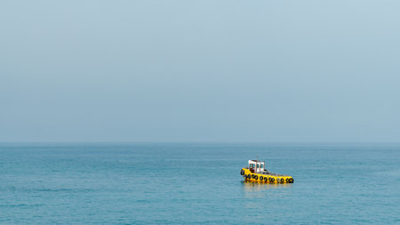 Yellow tugboat in the Mediterranean Sea. Minimal background.の写真素材