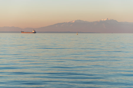 Ship in the sea on background of mountains during sunrise. Greece.の写真素材