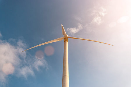 Wind turbines on a sunny day on sky background. Green energy generation concept.