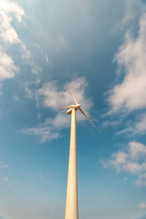 Wind turbines on a sunny day on sky background. Green energy generation concept.