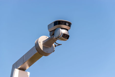 Street surveillance camera on sky background.