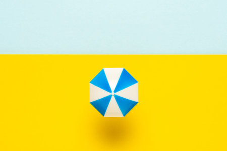Toy beach with sun umbrella and sea. Vacation minimal concept. Flat lay holiday background.