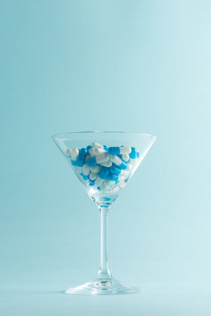 Creative layout with martini glass full of blue pills. Minimal concept.の写真素材