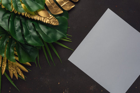 Creative layout with gold and green tropical palm leaves with white frame on black background....