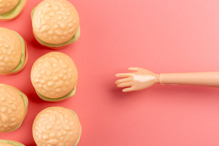 Colorful candy hamburgers with a hand of doll. Minimal food concept.の写真素材