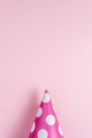 Party hat on pink background. Creative minimal holiday concept.の写真素材