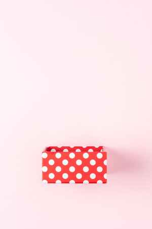 Red gift box on pink background. Minimal holiday concept.の写真素材