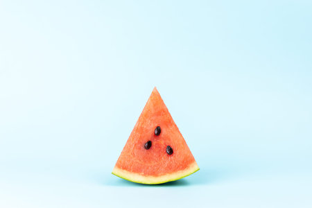 A slice of watermelon on pastel blue background. Summer holiday concept.