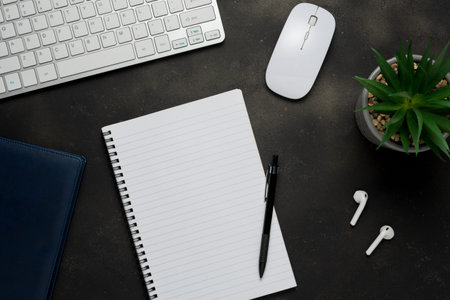Modern desk with keyboard, earphones, office supplies. Top view with copy space.