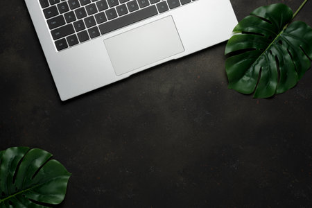 Top view of laptop on black background. Flat lay, top view office table desk.の写真素材