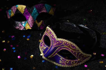 Close-up view of Masquerade mask with confetti on black background.の写真素材