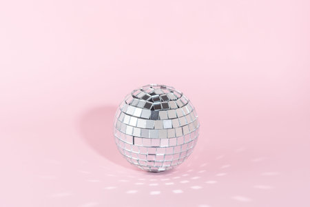 Shining disco ball on pink background. Minimal party concept.