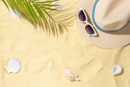 Sea sand with hat, sunglasses and shells. Top view with copy space.