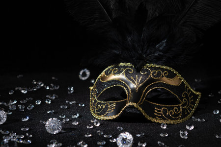Carnival gold mask with diamonds on black background.の写真素材