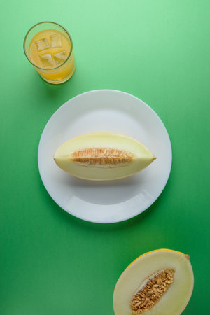 Melon sliced on bright green background. Minimal fruit concept.の写真素材