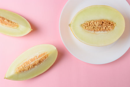 Melon sliced on pastel pink background. Minimal fruit concept.の写真素材