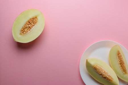 Melon sliced on pastel pink background. Minimal fruit concept.の写真素材