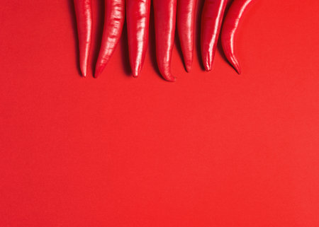 Creative layout of chili pepper on red background. Minimal food concept.の写真素材