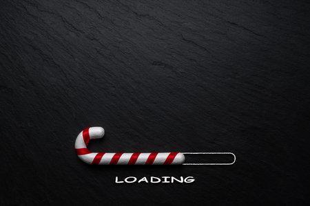Creative Christmas concept made of Candy cane on black stone background. Minimal Christmas loading...