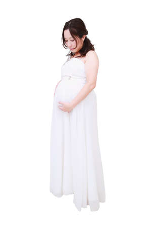 A beautiful smiling pregnant woman on white.の写真素材