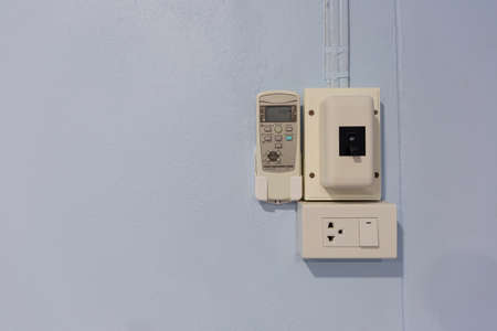 White bridge box with power control switch inside the house and remote air conditioner wiring on concrete wall. With electrical equipment objectsの写真素材