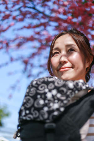 Portrait of close up woman standing looking and smiling happy carrying bag black white cherry blossom background
Bokeh blur and copy spaceの写真素材