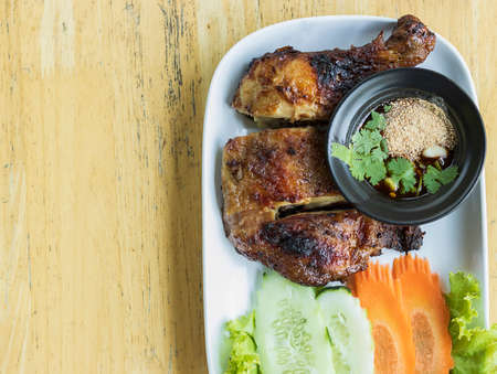 Grilled Chicken Drumsticks with Dipping Saucefocus selection On a white plate with cucumbers carrots lettucevegetables and copy spaceの写真素材