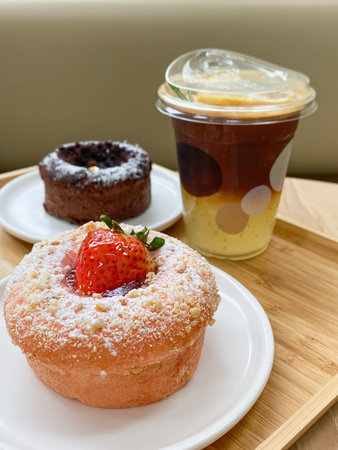 Sweet strawberry cheesecake with sweet chocolate and milk coffee mugs on the restaurant snack set...
