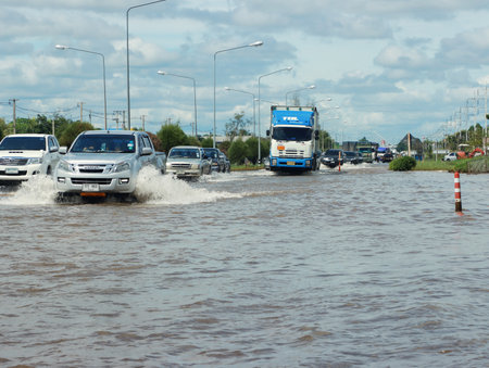 Nakhon Ratchasima, Thailand October 09,2022:driving cars splashing  wading carstorm flood road thai flood situation traffic emergency outdoorのeditorial素材
