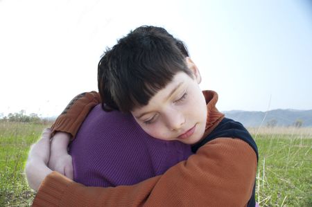 The white boy in Ð¾Ð±ÑÑÐ¸ÑÑ mums has put a head on a shoulderの写真素材