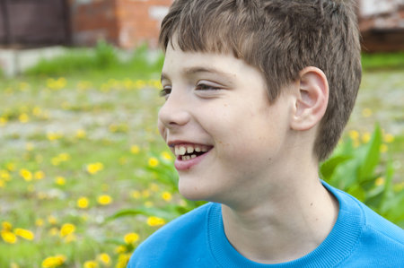 The boy on a glade among dandelions