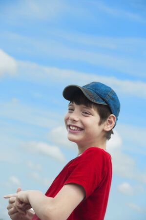 The happy boy against the blue skyの写真素材