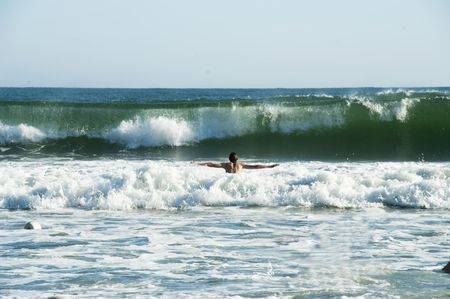 The young man is going to dive into a waveの写真素材