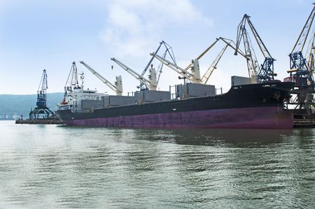 Vessel in port under loading of coal with open holdsの写真素材