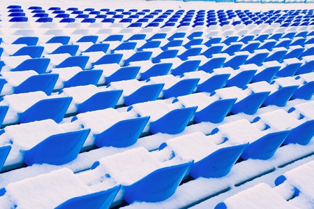  Blue benches at stadium in the winter under a snow layer の写真素材