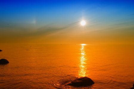 a yellow sunset with a warm glow. the sun is reflected in the waterの写真素材