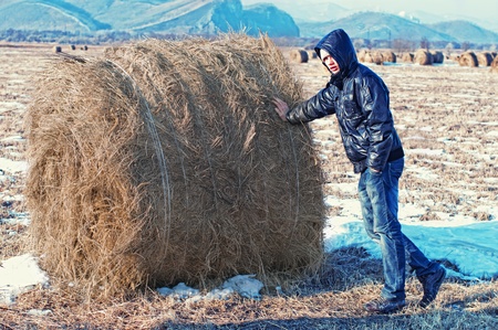 teenager stay, silhouette against haystackの写真素材