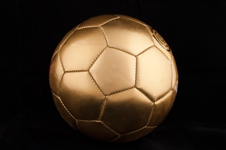 Gold soccer ball on  the black backgroundの写真素材