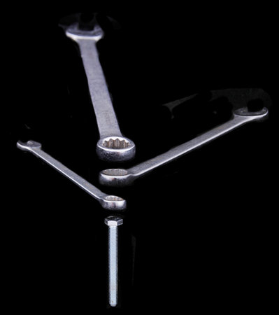 Wrench with a bolt isolated on a black background