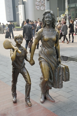 SHANGHAI, CHINA-15 OKT 2013 Bronze statue of a woman with child  Nanjing Road is the main shopping street of Shanghai and is one of the worldのeditorial素材
