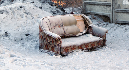 brokenness old sofa standing in the snowの写真素材