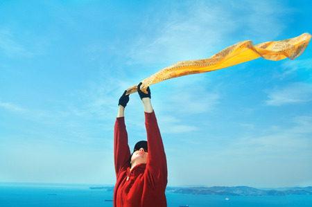 Freedom Concept.Girl with  Scarf standing on the Rock. Flying.Free.Vacationの写真素材