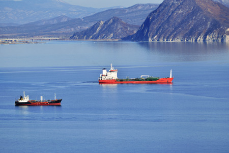 huge oil tanker and three tugboats at work.の写真素材
